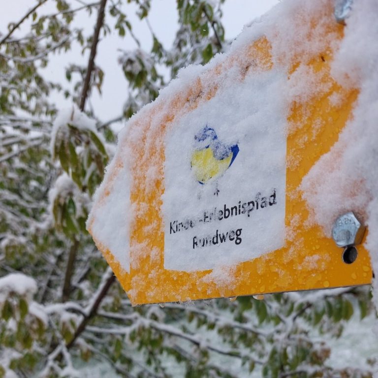 Wegweiser im Schnee zum Kinder-Erlebnis-Pfad.