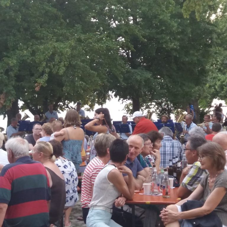 Publikum auf Bierbänken. Eine Veranstaltung direkt am Bodenseeufer in Sipplingen.